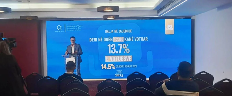 Conference speaker at a lectern in front of a blue LED video wall